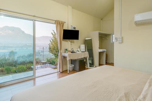 a bedroom with a bed and a large window at PATTA Hideaway Chiang Dao in Chiang Dao