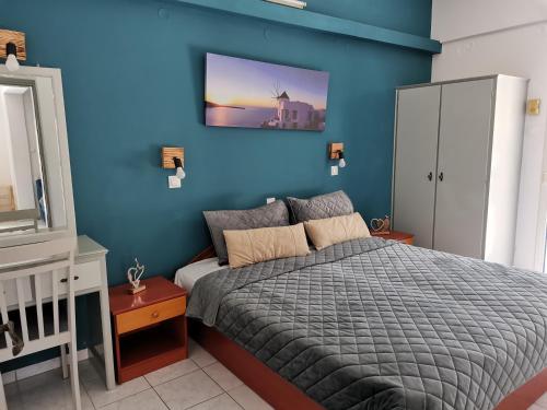 sypialnia z łóżkiem i niebieską ścianą w obiekcie Valentino's Apartment w mieście Panormos Kalymnos