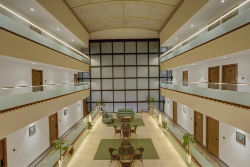 an empty hallway with tables and chairs in a building at Rajpath Beacon Hotel Belagavi in Belgaum