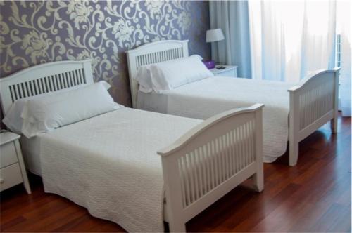 two white beds in a bedroom with a wall at Hotel Central Boutique in Marbella