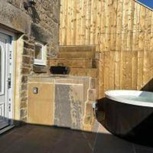 a bathroom with a sink and a brick wall at Foundry Farm Arch- pod inspired home in Hexham