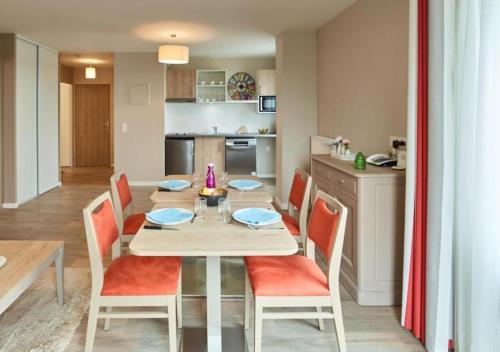 a kitchen and dining room with a table and chairs at Zenao Appart'hôtels Suresnes in Suresnes