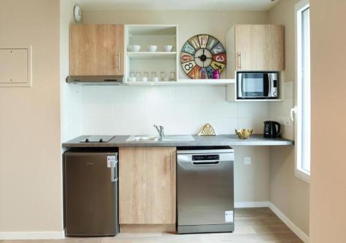a kitchen with a sink and a dishwasher at Zenao Appart'hôtels Suresnes in Suresnes