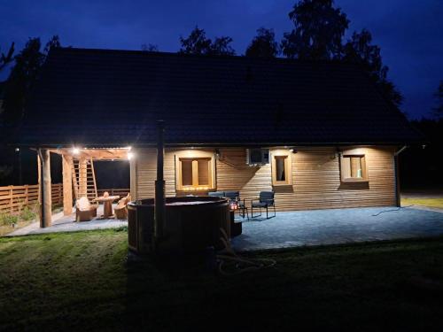 a small wooden house with a patio at night at Radość o poranku in Smardzew