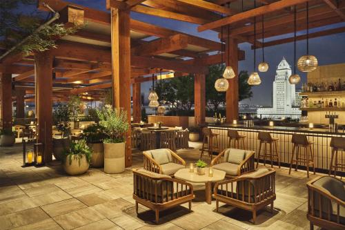a restaurant with chairs and tables and a bar at Conrad Los Angeles in Los Angeles