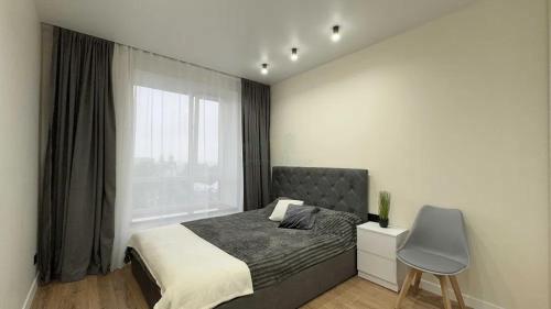 a bedroom with a bed and a chair and a window at Apartment in Irpin Pavlenka in Irpin