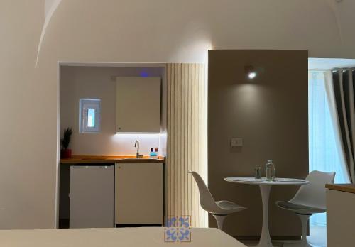 a kitchen with a table and a table and chairs at Passo Lento Charme Rooms in Gravina in Puglia