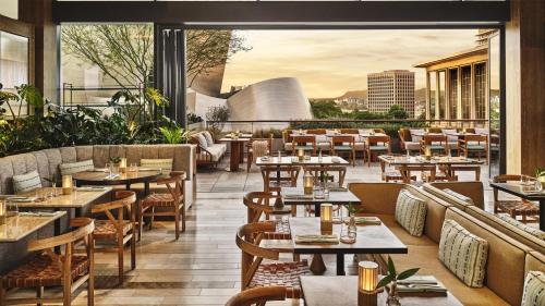 a restaurant with tables and chairs on a patio at Conrad Los Angeles in Los Angeles