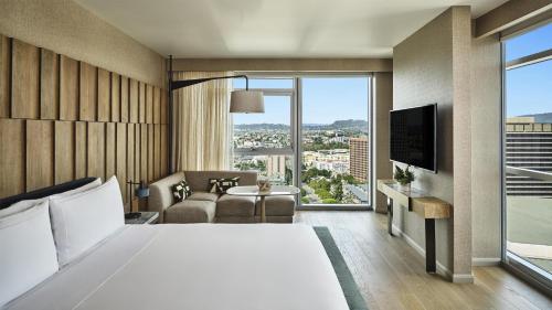 a hotel room with a bed and a large window at Conrad Los Angeles in Los Angeles