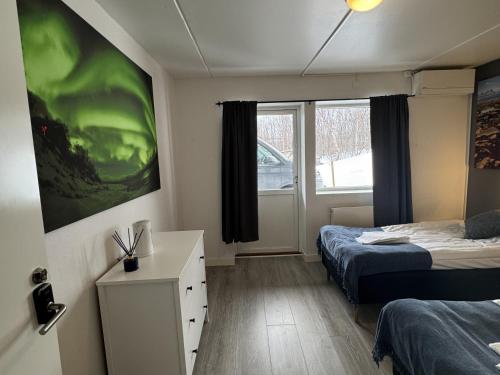 a small room with two beds and a window at Abisko Hostel in Abisko