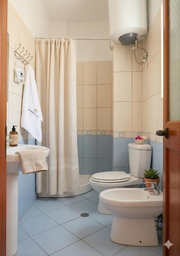 a bathroom with a toilet and a sink and a shower at Apartments Vila Cala in Durrës