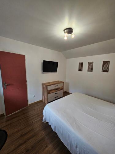 a bedroom with a bed and a flat screen tv at Gite Le Reposoir Argoules in Argoules