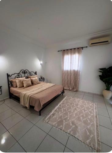 a bedroom with a large bed and a rug at Villa lina in Midoun