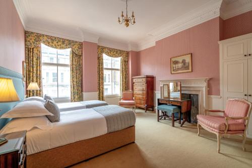 a bedroom with pink walls and a bed and a desk at No1 The Mansions By Mansley in London