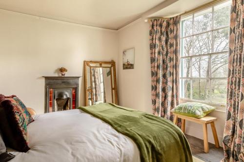 a bedroom with a bed and a mirror and a window at 4 Bed in Barnstaple oc-n34877 in Tawstock
