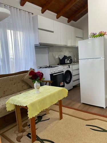 a kitchen with a couch and a table and a refrigerator at Vila Palma in Draç