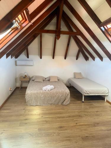 a bedroom with a bed in a attic with wooden floors at Villa Lolyka in Terre-de-Haut