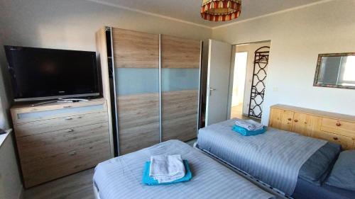 ein Schlafzimmer mit Fernseher und Bett und einem Fernseher in der Unterkunft FeWo Wölfer in Velten