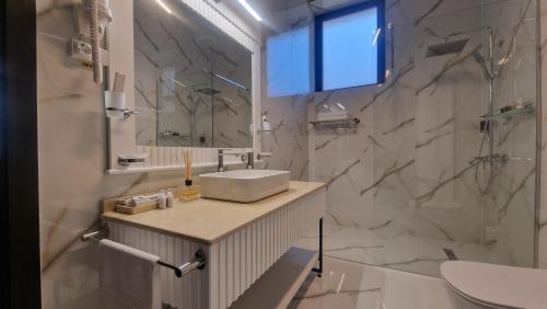 a white bathroom with a sink and a mirror at Pensiunea Casa Mitus in Strehaia