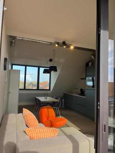 a room with a bed and a table and a kitchen at Bomaison charmant landelijke studio in Aalter