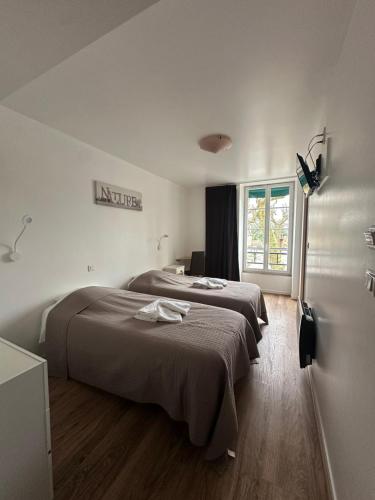 a bedroom with two beds and a window at Le Rhum Antik in Puybrun