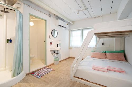 a bedroom with a bunk bed and a bathroom at Green Group Hotel & Pool Bangkok Old Town in Bangkok