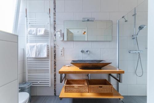 a bathroom with a sink and a shower at Hotel Kijkduin in Domburg