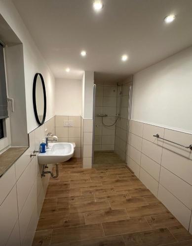 ein Badezimmer mit Waschbecken und Dusche in der Unterkunft Deich Kate in Wurster Nordseeküste