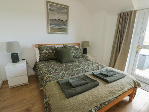 a bedroom with a bed with two pillows on it at Bwthyn in Moelfre