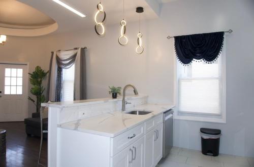 a white kitchen with a sink and a mirror at Master room w private bathroom 23 in Guttenberg
