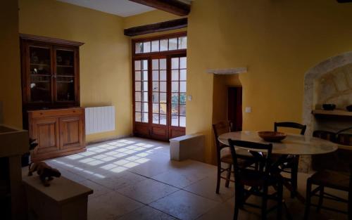 une cuisine avec une table et des chaises dans une pièce dans l'établissement Spa Roquemaure, à Roquemaure