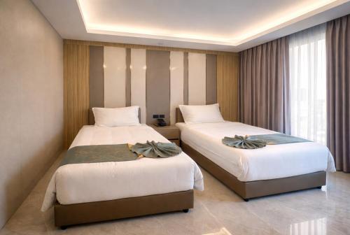 a hotel room with two beds and a window at Palette Bangkok Airport Hotel in Bangkok