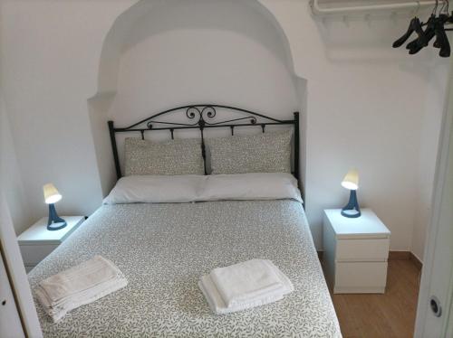 a bedroom with a large bed with two lamps on tables at Il sottano borgo antico in Bari