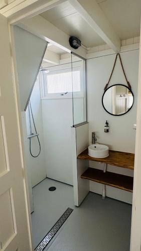 a small bathroom with a sink and a mirror at SandCsleep in Katwijk