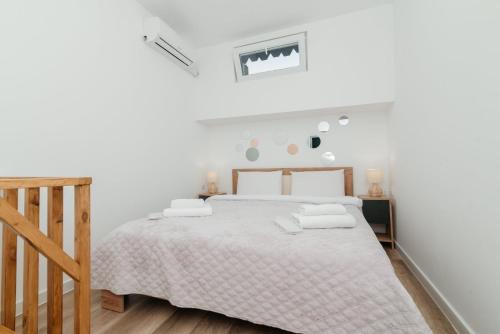 ein weißes Schlafzimmer mit Bett und Holzboden in der Unterkunft ERA Studios 4 in Chişinău