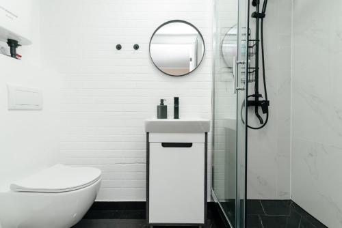 ein weißes Badezimmer mit Waschbecken und Spiegel in der Unterkunft ERA Studios 4 in Chişinău