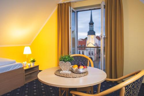 a room with a table with a bowl of fruit on it at Hotel Stadt Spremberg in Spremberg