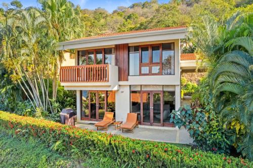 a house with a balcony and chairs in the yard at Bahia Pez Vela Resort in Ocotal