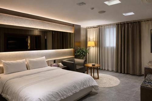 a hotel room with a bed and a chair at Zenith Tourist Hotel in Bucheon