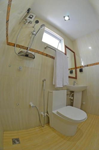 a bathroom with a toilet and a sink and a window at HS Miracle View in Hulhumale