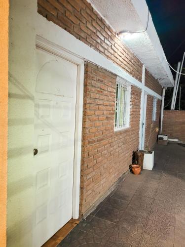 a white door on the side of a brick wall at Cactus del Valle 2 in Tinogasta