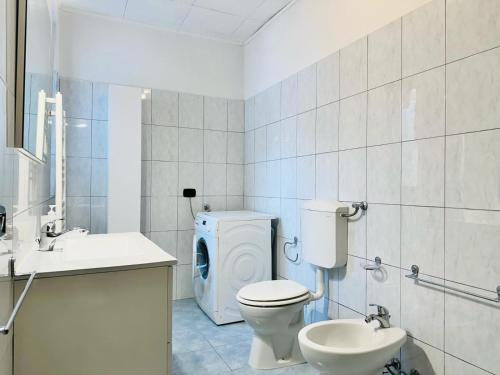 a bathroom with a toilet and a sink and a washing machine at Piccola Luna in Menaggio