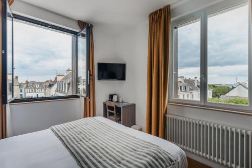 a bedroom with a bed and two large windows at Hôtel & Spa de la Citadelle, Port-Louis - Lorient in Port-Louis