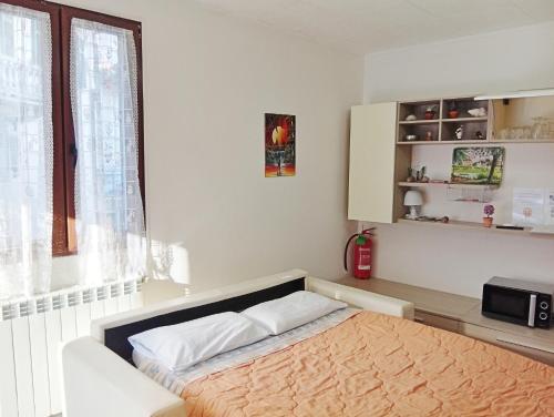 a bedroom with a bed with a microwave and a window at Piccola Luna in Menaggio