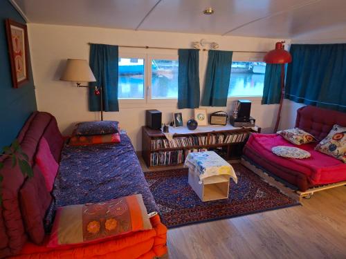 a living room with a couch and a bed and a table at Bateau Escapade in Ramonville-Saint-Agne