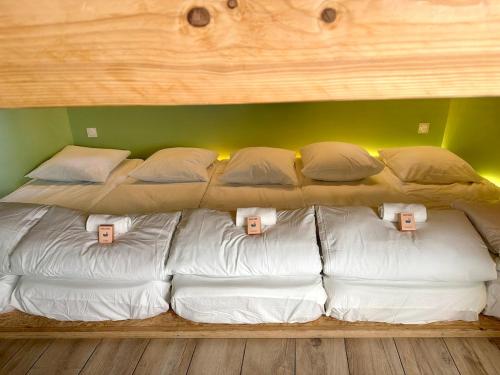 a large bed with white sheets and pillows on it at Sleep and Go Lyon Oullins in Oullins