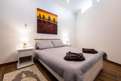 a bedroom with a bed and a painting on the wall at V86 - Charming 1 Bedroom Isla Duplex Apt with Harbour Views in Senglea