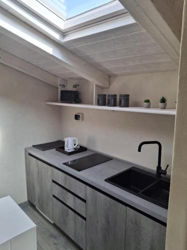 a kitchen with a sink and a skylight at Il Nido della Piazzetta in Saluzzo