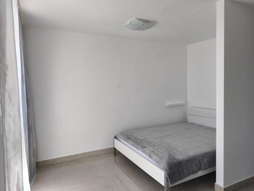 a small bed in a room with white walls at SunBreeze in Igalo