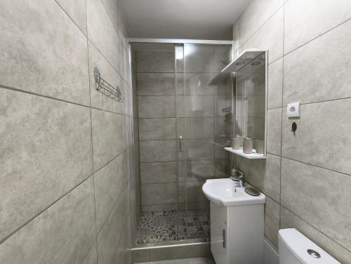 a bathroom with a shower and a toilet and a sink at SunBreeze in Igalo